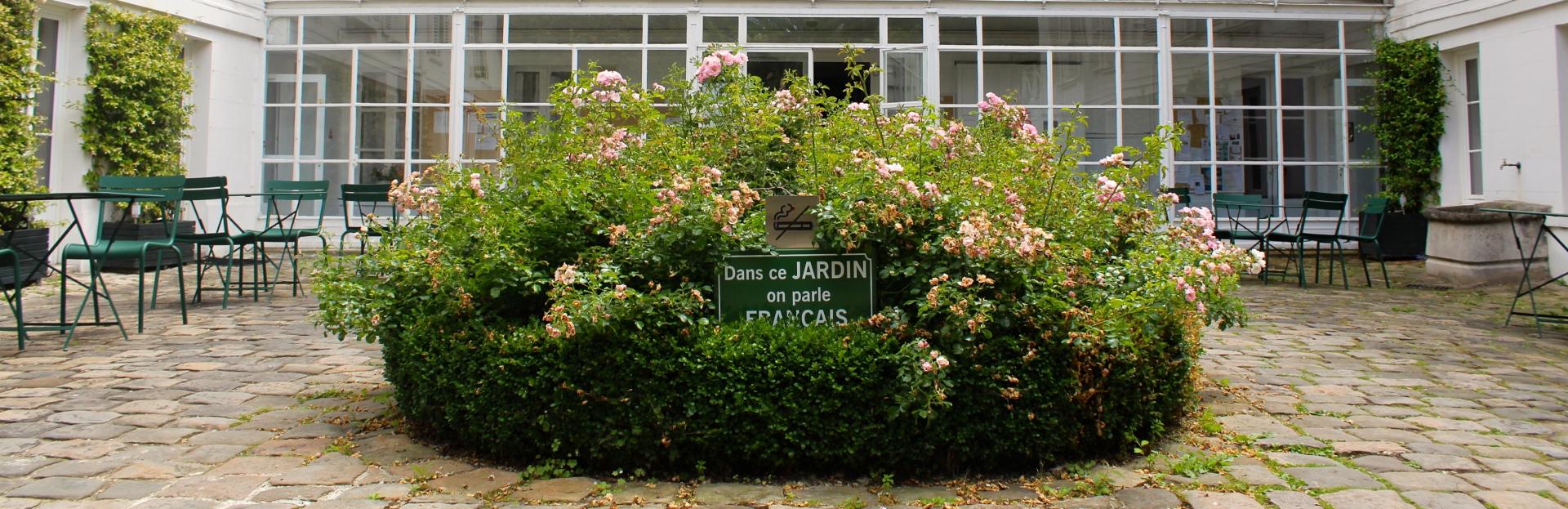 reid hall garden with sign "dans ce jardin on parle français"